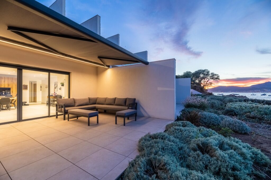 Store banne BIO KD BIOSSUN de nuit avec éclairage LED intégré sur une belle terrasse en Corse
