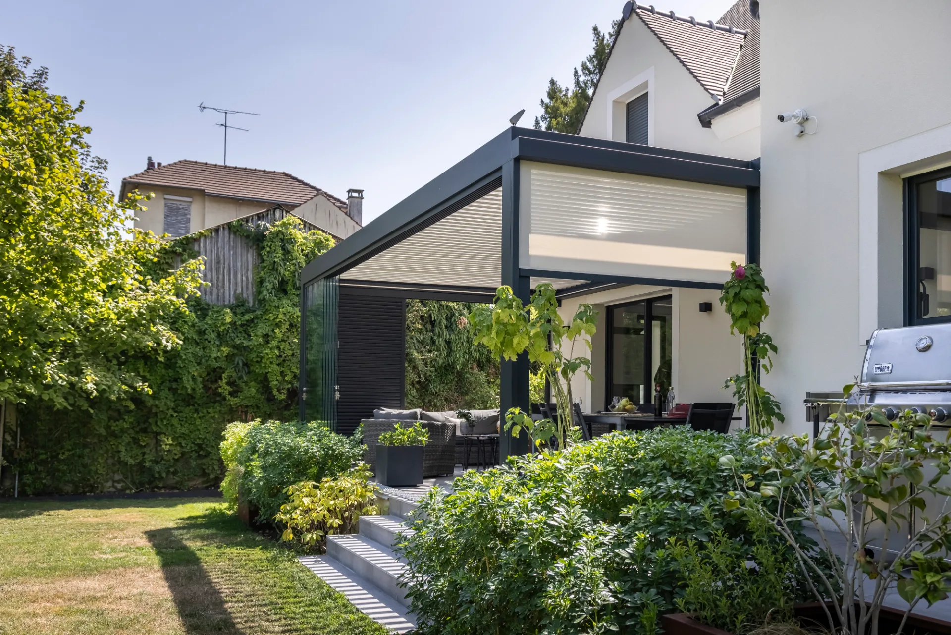 Pergola bioclimatique Biossun en Ile de France avec store, vitrages et claustras